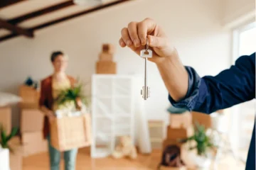 person holding a key and another person behind the getting ready to leave a rental